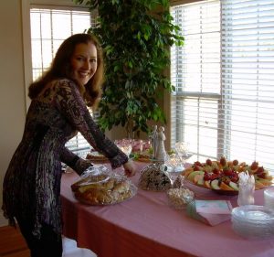 A woman putting food on a table.